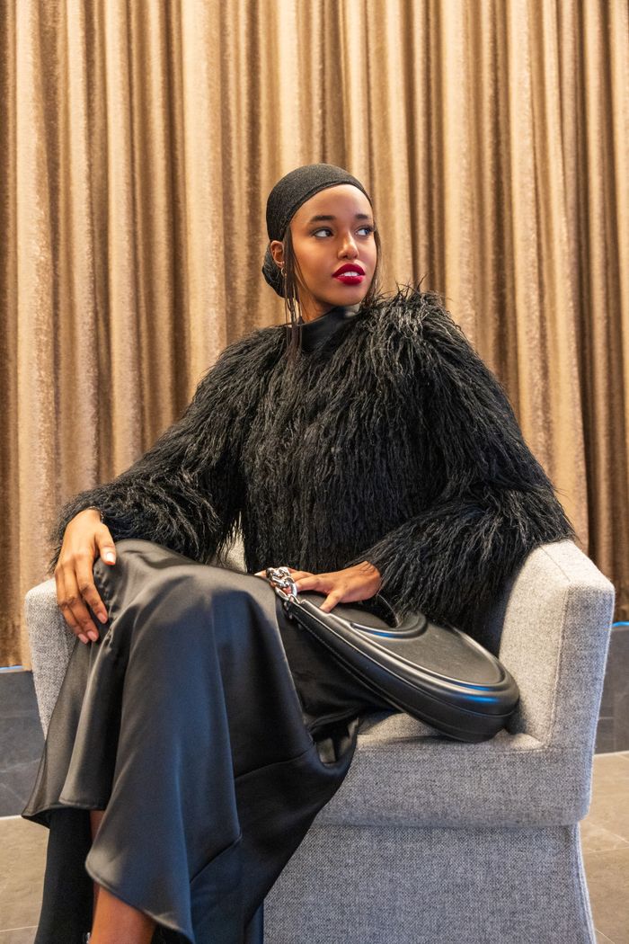 Chic portrait of a woman in black fashion attire in a sophisticated setting.